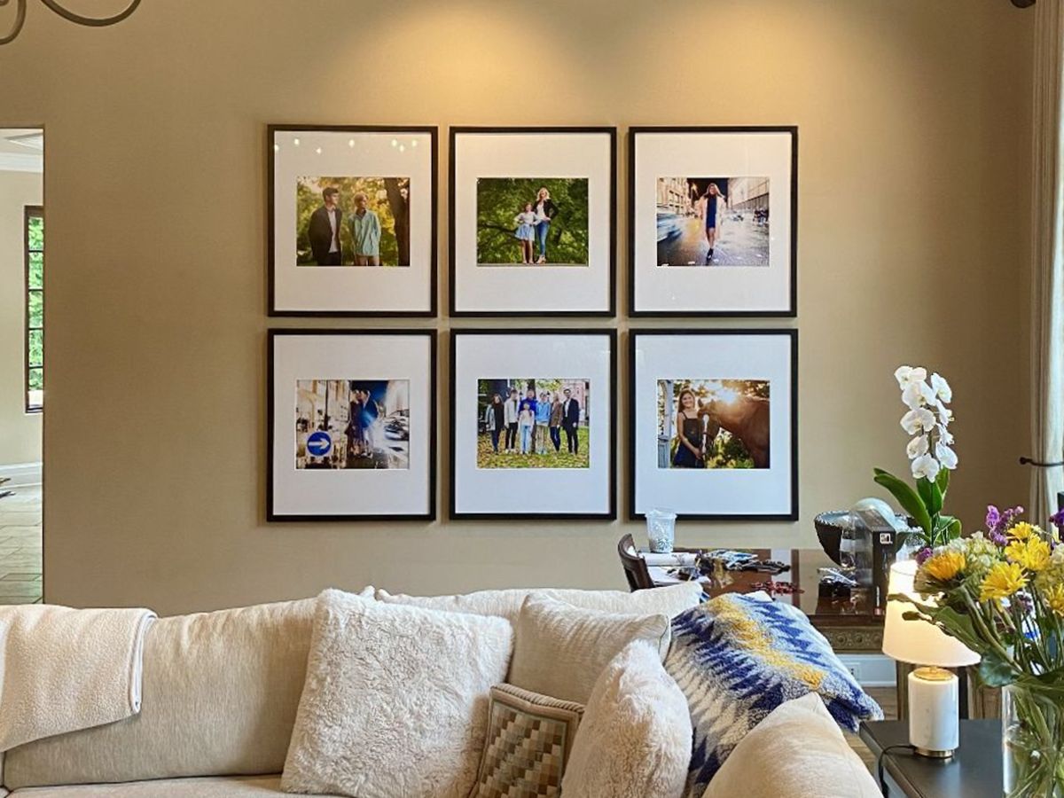 Six framed family photos placed on a living room wall