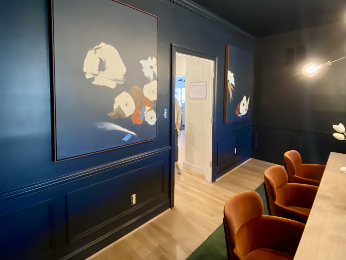 Meeting room with dark blue walls and large framed art