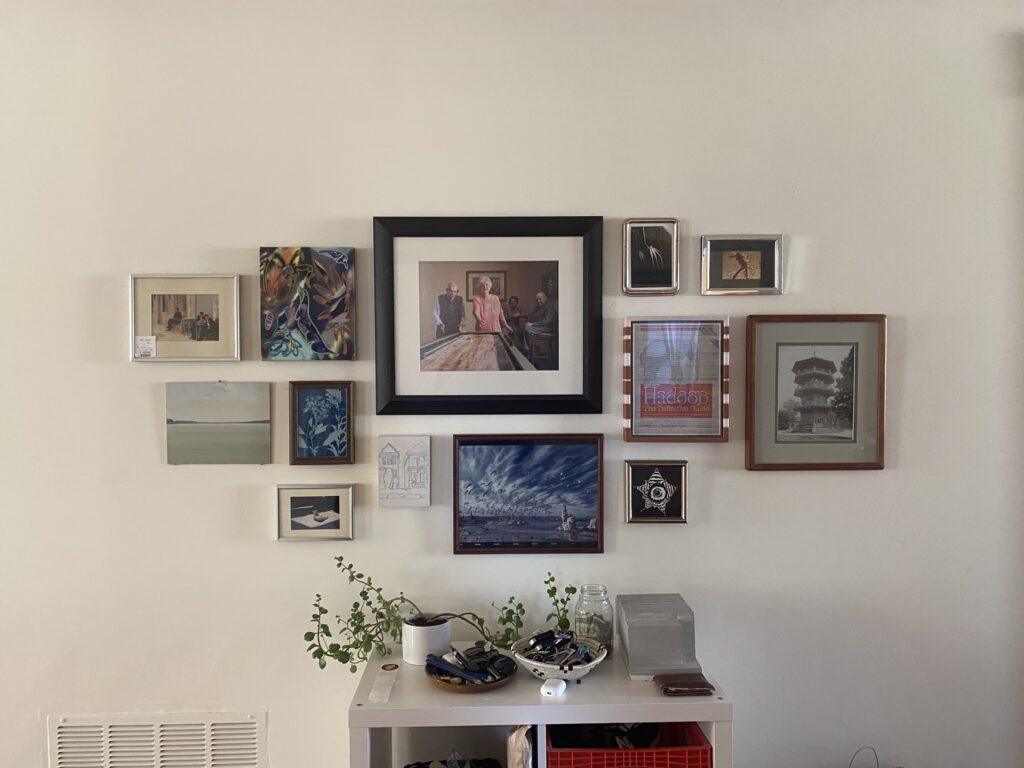 Professional art installation experts hanging a multifamily artwork on a wall